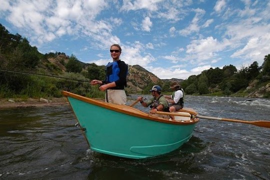 a man riding on the back of a boat in a body of water